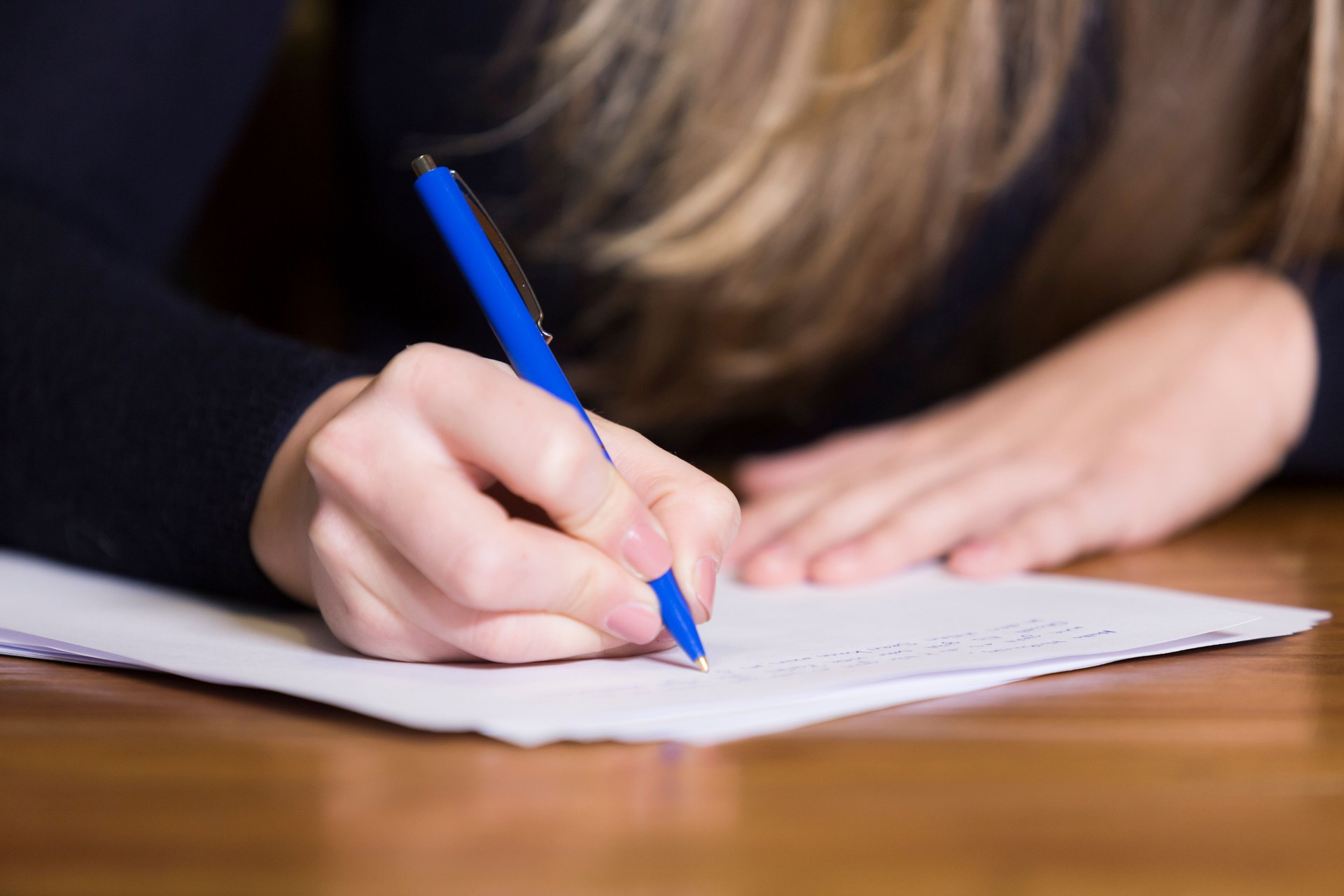 Female hand writing on paper